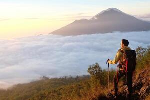 Peak Paradise, Asian Model on Mount Batur Summit with Ocean of Clouds under Azure Sky photo
