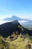 Asian Adventure, Man Model on Mountain Summit, Carrying Hiking Gear under Blue Sky above Ocean of Clouds photo