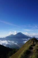Peak Paradise, Asian Model on Mount Batur Summit with Ocean of Clouds under Azure Sky photo