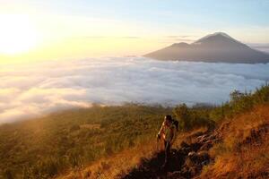 Peak Paradise, Asian Model on Mount Batur Summit with Ocean of Clouds under Azure Sky photo