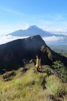 Asian Adventure, Man Model on Mountain Summit, Carrying Hiking Gear under Blue Sky above Ocean of Clouds photo