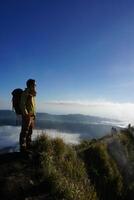 Peak Paradise, Asian Model on Mount Batur Summit with Ocean of Clouds under Azure Sky photo