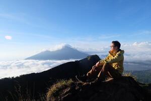 Peak Paradise, Asian Model on Mount Batur Summit with Ocean of Clouds under Azure Sky photo