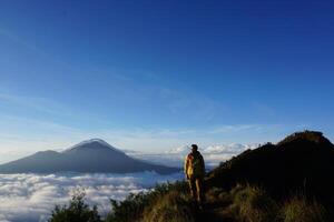 Peak Paradise, Asian Model on Mount Batur Summit with Ocean of Clouds under Azure Sky photo