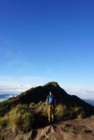 Peak Paradise, Asian Model on Mount Batur Summit with Ocean of Clouds under Azure Sky photo