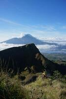 Peak Paradise, Asian Model on Mount Batur Summit with Ocean of Clouds under Azure Sky photo