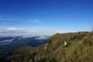 Peak Paradise, Asian Model on Mount Batur Summit with Ocean of Clouds under Azure Sky photo