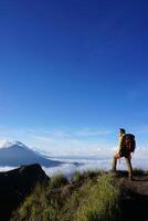 Peak Paradise, Asian Model on Mount Batur Summit with Ocean of Clouds under Azure Sky photo