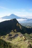 Asian Adventure, Man Model on Mountain Summit, Carrying Hiking Gear under Blue Sky above Ocean of Clouds photo