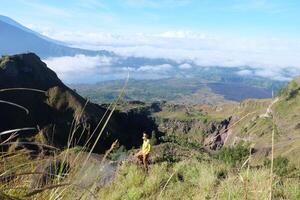 Asian Adventure, Man Model on Mountain Summit, Carrying Hiking Gear under Blue Sky above Ocean of Clouds photo