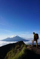 Peak Paradise, Asian Model on Mount Batur Summit with Ocean of Clouds under Azure Sky photo