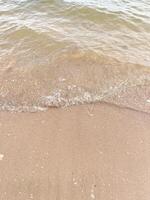 Soft wave of blue ocean on sandy beach. Background. photo