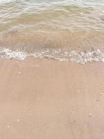 Soft wave of blue ocean on sandy beach. Background. photo