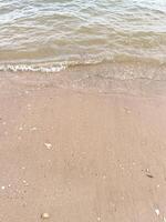 Soft wave of blue ocean on sandy beach. Background. photo