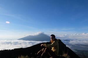 Peak Paradise, Asian Model on Mount Batur Summit with Ocean of Clouds under Azure Sky photo