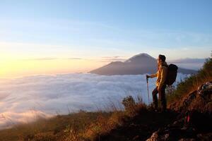 Peak Paradise, Asian Model on Mount Batur Summit with Ocean of Clouds under Azure Sky photo