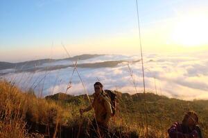 hacia el cielo cumbre, asiático modelo en montar batur, que lleva excursionismo engranaje en medio de nube Oceano foto