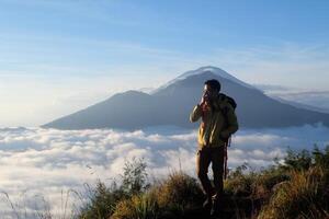 Peak Paradise, Asian Model on Mount Batur Summit with Ocean of Clouds under Azure Sky photo