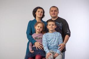 studio portrait of a happy family husband wife daughter and son 12 photo