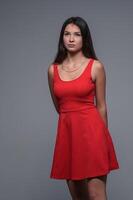 estudio retrato de un joven hermosa niña en un rojo vestir 1 foto