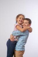 sister hugging brother studio portrait happy family 1 photo