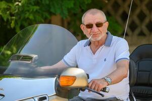 elderly man sitting on a motorcycle 3 photo