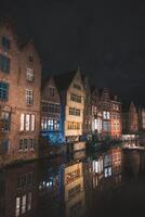 View of classic medieval houses reflected in a water canal in the centre of Ghent, Flanders region, Belgium. Colourful facades of the houses of rich citizens photo