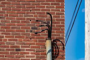 conduit on the side of a building with wires sticking out photo