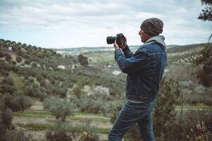 paisaje masculino fotógrafo en acción tomando imagen de montañas foto