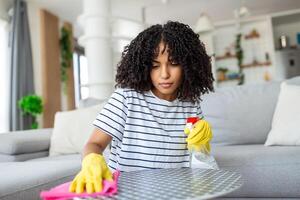 mujer limpieza y pulido el mesa con un rociar detergente, limpieza interna y higiene concepto foto
