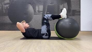 mujer en el gimnasio realiza abdominal ejercicios con un ajuste pelota. individual capacitación. foto