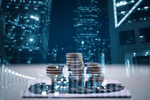 Finance and Investment concept. Money management and Financial chart. Double exposure of city and rows of coins for finance and business. Stack of money coin with trading graph, financial investment. photo