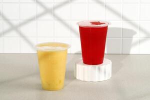 Red and Yellow Juice on Sealed Plastic Cup. On the Go Juice photo