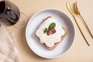 Belgian waffles with strawberry confit and cream sauce on beige background photo