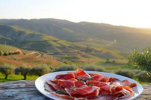 ai generado plato de jamon ibérico con el laminación colinas de Andalucía en suave puesta de sol ligero - auténtico Español delicadeza foto