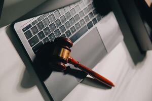 image of judge's hammer, scales lady of justice, law book, laptop computer and contract documents with pen concept of law and justice. photo