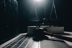 image of judge's hammer, scales lady of justice, law book, laptop computer and contract documents with pen concept of law and justice. photo