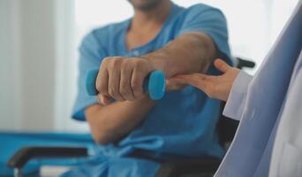 Physiotherapist man giving exercise with dumbbell treatment About Arm and Shoulder of athlete male patient Physical therapy concept photo