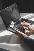 businessman working on desk office with using a calculator to calculate the numbers, finance accounting concept photo