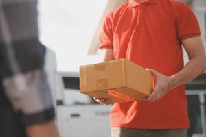 asiático entrega Rápido mensajero joven hombre utilizar dando cajas a mujer cliente él vistiendo protector cara máscara a frente hogar foto