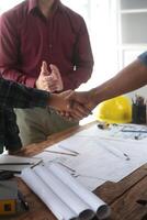 Engineer and contractor join hands after signing contract,They are having a modern building project together. successful cooperation team concept photo