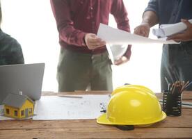 Diverse Team of Specialists Use Laptop on Construction Site. Real Estate Building Project with Engineer Investor and Businessman Checking Area, working on Civil Engineering, Discussing Strategy Plan photo