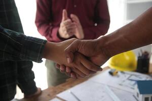 Engineer and contractor join hands after signing contract,They are having a modern building project together. successful cooperation team concept photo