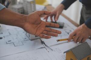 Construction and structure concept of Engineer or architect meeting for project working with partner and engineering tools on model building and blueprint in working site, contract for both companies. photo