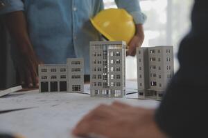 Construction and structure concept of Engineer or architect meeting for project working with partner and engineering tools on model building and blueprint in working site, contract for both companies. photo