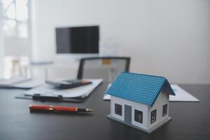 Real estate agent and Sales manager team analysis pricing of rental lease contract of sale purchase agreement, concerning mortgage loan offer for and house insurance. photo