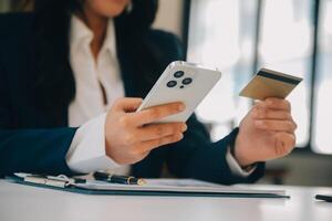 Women holding credit card and using smartphones at home.Online shopping, internet banking, store online, payment, spending money, e-commerce payment at the store, credit card, concept photo