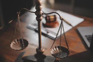 image of judge's hammer, scales lady of justice, law book, laptop computer and contract documents with pen concept of law and justice. photo
