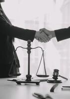 concepto de justicia y derecho. El asesor legal presenta al cliente un contrato firmado con mazo y derecho legal o una reunión de equipo legal en el bufete de abogados en segundo plano. foto