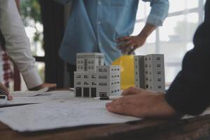 Construction and structure concept of Engineer or architect meeting for project working with partner and engineering tools on model building and blueprint in working site, contract for both companies. photo